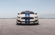 the front end of a white and blue mustang