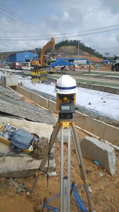 a tripod with a camera on top of it in the middle of construction work