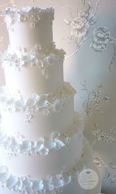 three tiered wedding cake with white frosting flowers on the top and bottom layer