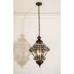 a light fixture hanging from the ceiling in a room with a shadow on the wall