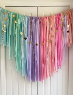 there is a rainbow streamer hanging from the front door with stars on it,