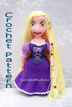 a crocheted doll with long blonde hair wearing a purple dress and beaded headband