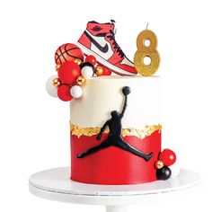 there is a red and white cake with a basketball theme on the top, along with other decorations