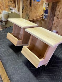 two unfinished wooden tables sitting on top of a hard wood floor in a shop or workshop