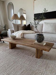 a living room filled with furniture and a large mirror on the wall above it's coffee table