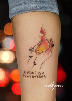 a woman's leg with a tattoo on it that says, a heart is a heavy burden