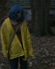 a woman with blue hair wearing a yellow raincoat