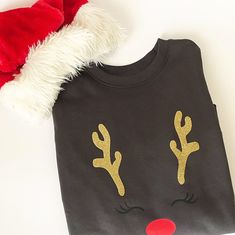 a t - shirt with reindeer antlers on it and a santa's hat