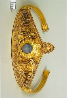 a gold bracelet with an oval stone in the center