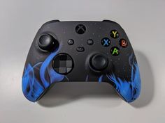 a close up of a game controller on a white surface with blue and black designs