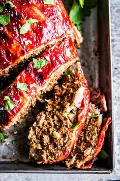 sliced meatloaf with sauce and herbs on top