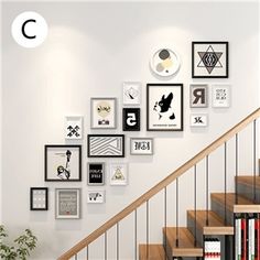 there are many framed pictures on the wall next to the stair case and bookshelf