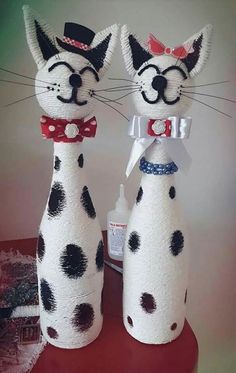 two dalmatian cats made out of toilet paper on top of a red table