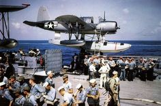 an airplane flying over a group of people on a boat