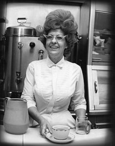 a woman sitting at a table with a cup and saucer