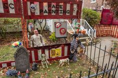 two people dressed up as clowns in front of a house with halloween decorations on it