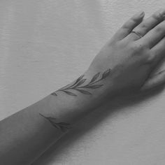 a woman's hand with a tattoo on it, holding her left arm up