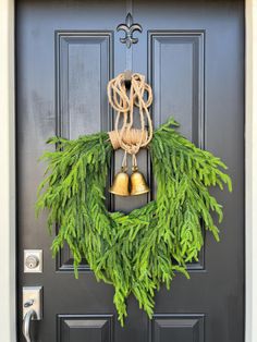 a wreath with bells hanging from it's side on the front door to welcome guests