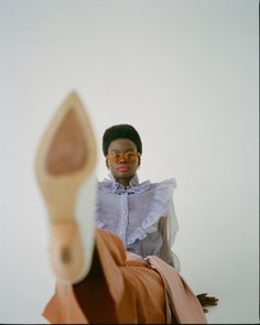 a woman sitting on top of a bed next to a wooden shoe