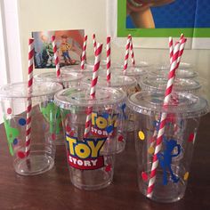 there are many cups with straws in them on the table next to each other