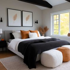 a bedroom with white and black bedding, two framed pictures on the wall above it