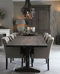 a dining room table with chairs and a chandelier hanging from it's ceiling