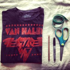 a pair of scissors, t - shirt and other items laid out on a bed