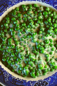 peas are in a bowl on a blue and white plate