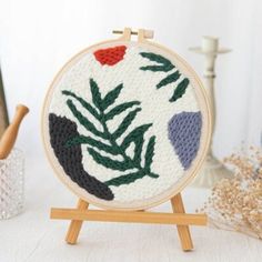 a small wooden easel holding an embroidery project