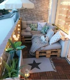 a small balcony with lights and pillows on the floor, an outdoor seating area has a dog sitting on it