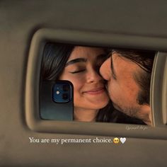 a man and woman kissing in the back seat of a car while taking a selfie