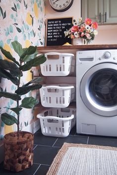 a washer and dryer sitting next to each other in front of a clock