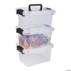 two plastic storage containers with black handles and lids filled with colorful rubber bands on white background