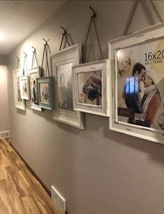 there are pictures hanging on the wall in this hallway, along with other framed photos