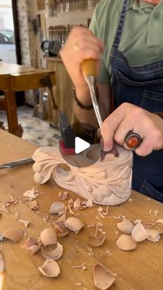 a person using a pair of scissors to cut up some kind of material on a table