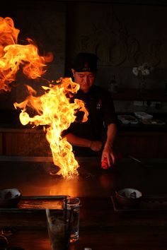 a man standing in front of a table covered in flames