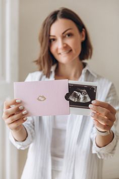 a woman holding up a card with an image on it