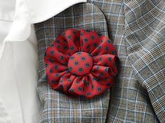 a red flower on the lapel of a jacket