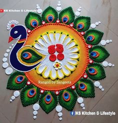 rangoli diya with peacock and candles on the floor