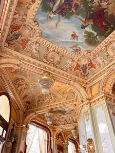 an ornate ceiling with paintings and chandeliers