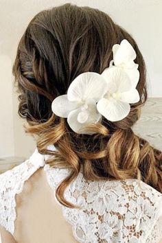 the back of a woman's head with white flowers in her hair and lace on it