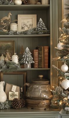 a christmas tree and other decorations on a shelf in a room with green painted walls