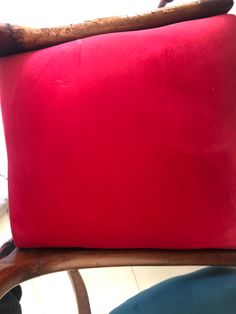 a red cushion sitting on top of a wooden chair