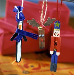 two wooden peg dolls hanging from strings on a table