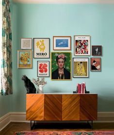 a living room with blue walls and pictures on the wall, including a sideboard