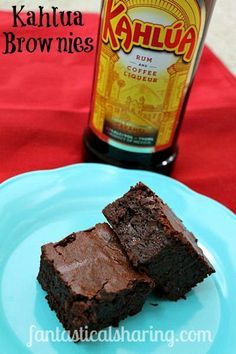 two brownies on a blue plate with a bottle of kahlua in the background