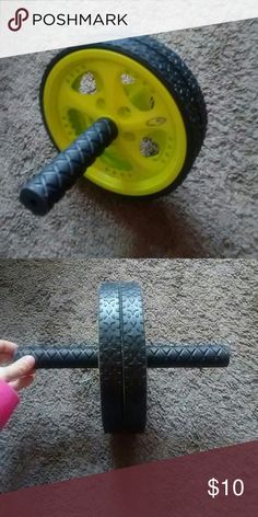 a person is holding a barbell in front of a yellow wheel on the floor