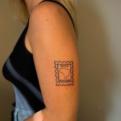 a woman with a stamp tattoo on her arm