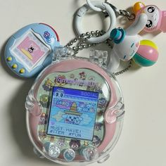 an electronic device keychain with several different items around it on a white surface