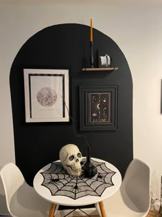 a white table topped with a skull sitting on top of a spider web covered table